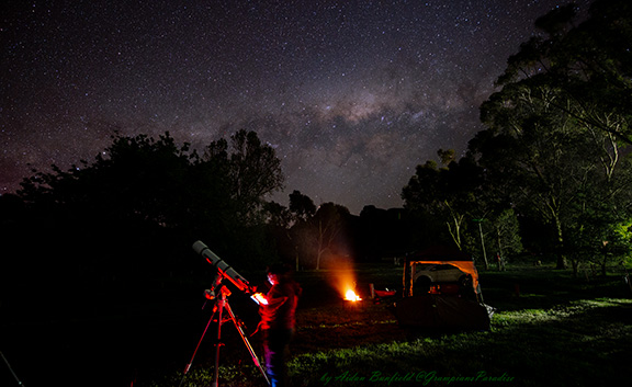 Sitting around a campfire under the stary sky at Grampians Paradise Camping and Caravan Parkland